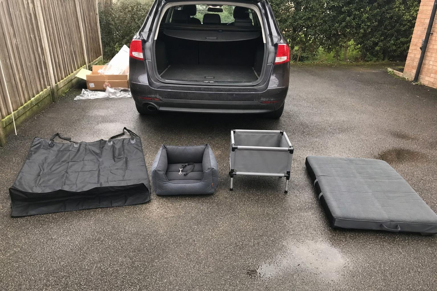 Four dog car travel products laid out on a driveway